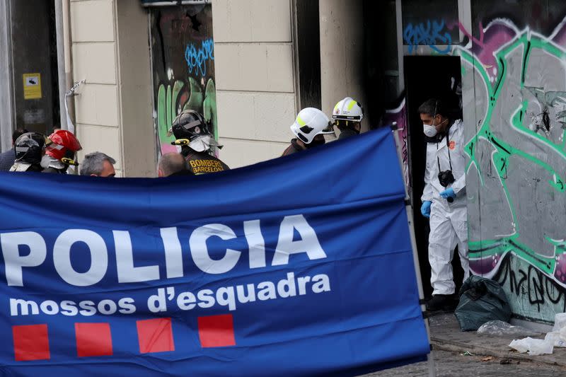 Police work at a burned building in Barcelona