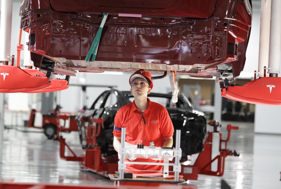 A worker works on the Tesla Model S at the Tesla factory in Fremont, Calif., Friday, June 22, 2012. The first Model S sedan car will be rolling off the assembly line on Friday. (AP Photo/Paul Sakuma)