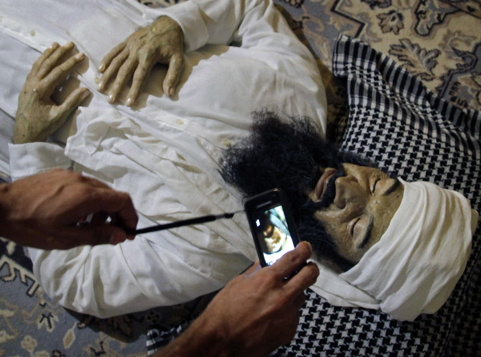 A student makes a picture with a smart phone of the realistic sculpture of the late al-Qaeda leader Osama bin Laden by artists Alberto Lorente, Manolo Castro and Julio Lorente titled "He" that is on display at the Superior Institute of Arts during the 11th Havana Biennial contemporary art exhibition in Havana, Cuba, Thursday, May 10, 2012. (AP Photo/Javier Galeano)