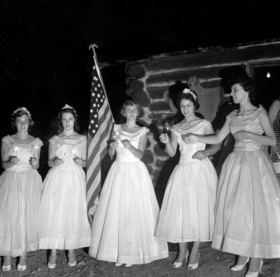 <p>The Queen of Candles and her maids light sparklers before leading the coronation procession, circa 1955. (Photo: Evans/Three Lions/Getty Images) </p>