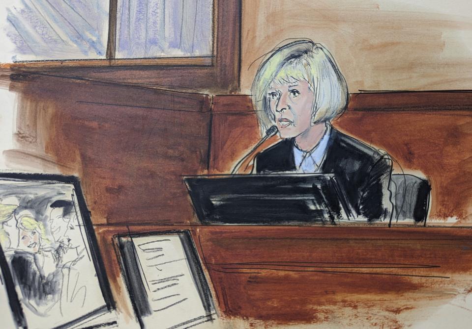 E. Jean Carroll testifies on the witness stand with a photo of herself and Donald Trump shown on the screen, far left, in the trial of her federal lawsuit, Wednesday, April 26, 2023, in New York. Carroll has told a jury that Donald Trump raped her after she accompanied him into a deluxe department store fitting room in 1996. (Elizabeth Williams via AP)