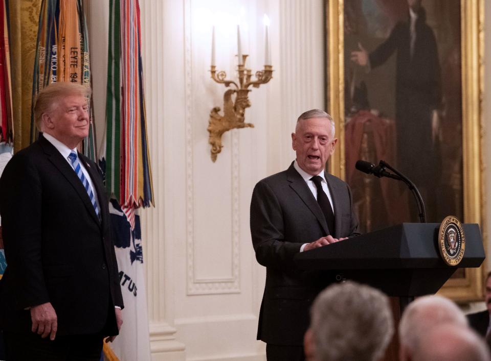 Defense Secretary Jim Mattis speaks at a reception as President Donald Trump looks on at the White House in 2018.