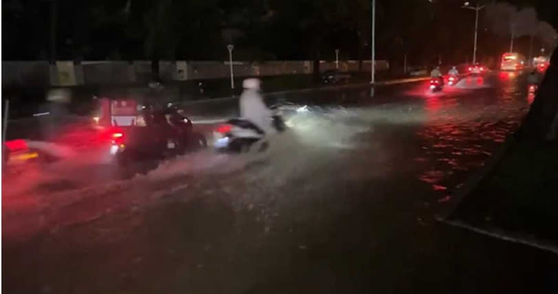 高雄市多地傳出淹水災情，騎士冒雨行駛積水道路。（圖／報系資料照）