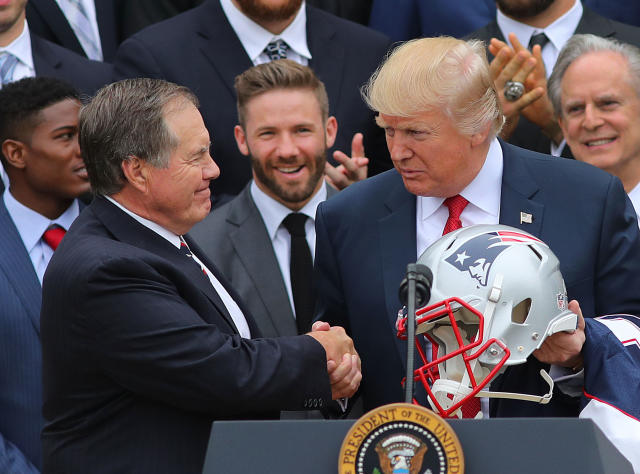 President Donald Trump holds a New England Patriot helmet as he