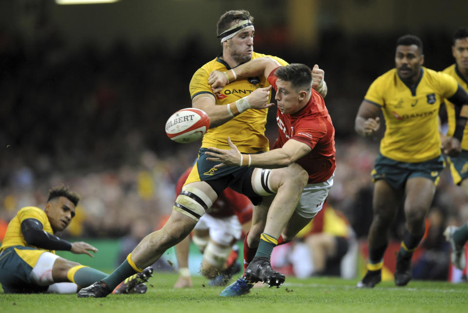 Wales Josh Adams, right, passes the ball as Australia's Izack Rodda comes in for the tackle during the rugby union international match between Wales and Australia at the Principality Stadium in Cardiff, Wales, Saturday, Nov. 10, 2018. (AP Photo/Rui Vieira)