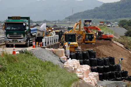 Workers conduct repair work on a destroyed embankment along Odagawa river in Mabi town in Kurashiki, Okayama Prefecture, Japan, July 13, 2018. Picture taken July 13, 2018. REUTERS/Issei Kato