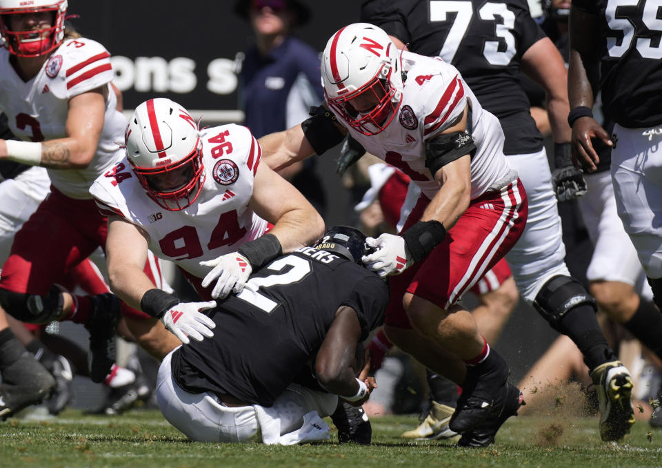 Colorado quarterback Shedeur Sanders, front, is sacked by Nebraska defensive lineman Riley Van Poppel, back left, and linebacker Luke Reimer in the second half of an NCAA college football game Saturday, Sept. 9, 2023, in Boulder, Colo. (AP Photo/David Zalubowski)