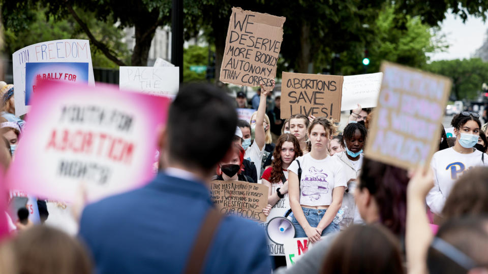 Abortion rights activists hold up signs at a rally in front of the Supreme Court building on May 5 in Washington, D.C.