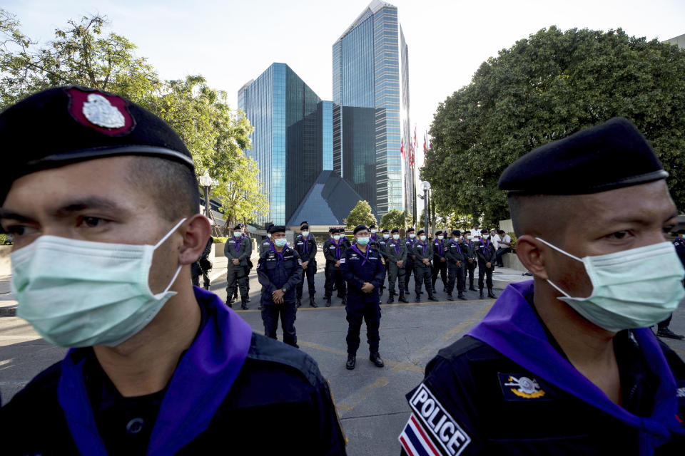 Police stand guard outside the Siam Commercial Bank where anti-government protesters are holding a rally Wednesday, Nov. 25, 2020, in Bangkok, Thailand. Thai authorities have escalated their legal battle against the students leading pro-democracy protests, charging 12 of them with violating a harsh law against defaming the monarchy. (AP Photo/Wason Wanichakorn)