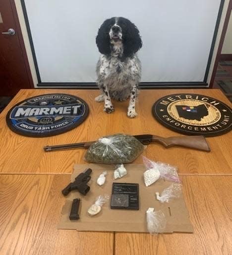 Marion Police Department K-9 Stash is shown with suspected illegal drugs and firearms that were seized during the raid of a Fairwood Avenue residence on Tuesday, Jan. 25, 2022. Two people were arrested and are facing charges in the case.