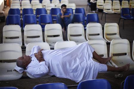 A stranded Palestinian passenger sleeps as he waits at Rafah crossing between Egypt and southern Gaza Strip, with hopes of crossing into Egypt, September 12, 2013. REUTERS/Ibraheem Abu Mustafa