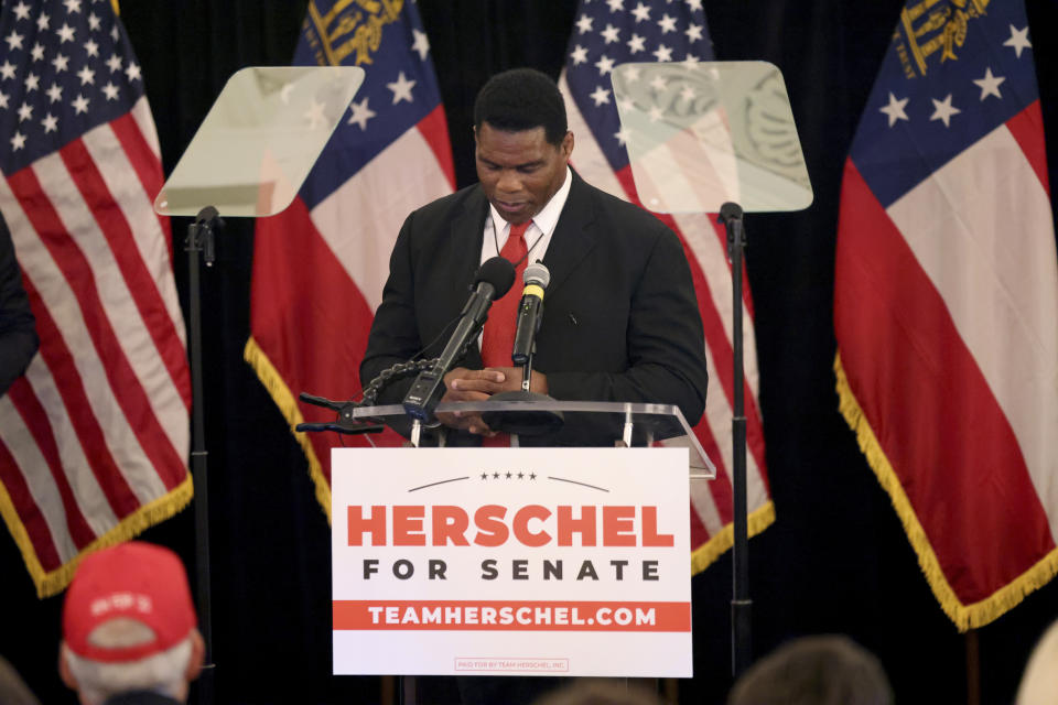 Herschel Walker holds a moment of silence for the school shooting in Texas before speaking after his Republican Primary win on Tuesday, May 24, 2022, at the Georgian Terrace Hotel in Atlanta. Walker would face U.S. Sen. Raphael Warnock, a Democrat, in November. (Jason Getz/Atlanta Journal-Constitution via AP)