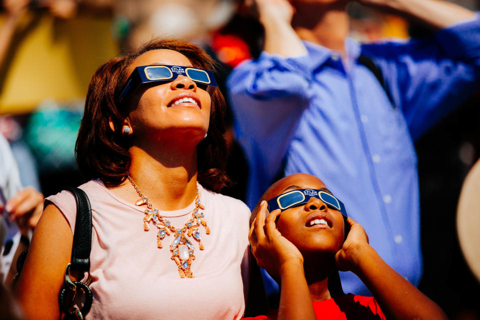 Spectators in Chapel Hill, NC look on to the solar eclipse. What do parents need to know about the solar eclipse? (Image via Getty)