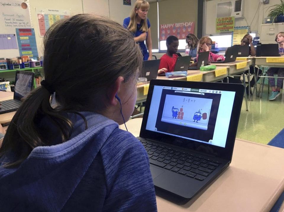 Students at a Connecticut elementary school work on math problems on the DreamBox system while their teacher works with other students in class. A wide array of apps, websites and software used in schools borrow elements from video games to help teachers connect with students living technology-infused lives.