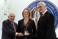 Geraldine Heaney receives her Hall of Fame ring from selection committee chair Jim Gregory, left, and Hall of Fame chair Pat Quinn, right.