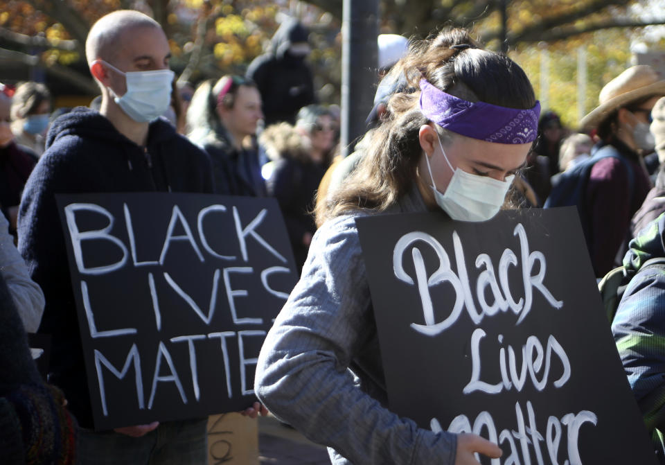 Demonstrators observe a minute's silence in Canberra, Australia, on Friday, June 5, 2020 in memory of deaths in custody including George Floyd, who died after being restrained by Minneapolis police officers on May 25. Thousands gathered in Australia's capital to remind Australians that the racial inequality underscored by Floyd's death was not unique to the United States. (AP Photo/Rod McGuirk)