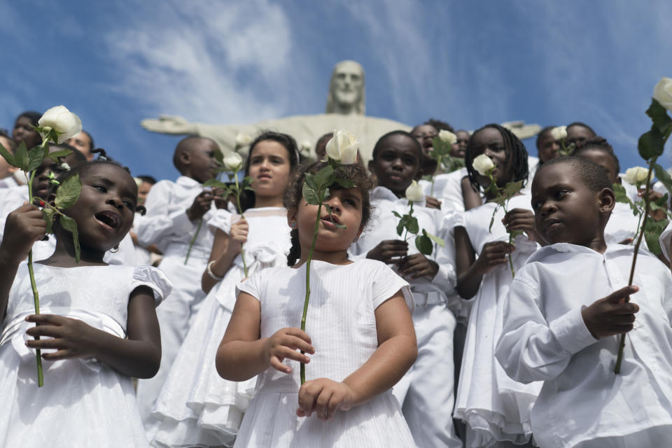 En esta imagen del miércoles 15 de marzo de 2017, niños refugiados cantan por la paz en un acto para conmemorar el 6to aniversario de la guerra en Siria, bajo la estatua de Cristo el Redentor en Río de Janeiro, Brasil. Según un reporte reciente de la ONG Save the Children, los menores sirios muestran síntomas de “estrés tóxico” y algunos intentan autolesionarse o suicidarse debido a su larga exposición a la guerra. (AP Foto/Renata Brito)