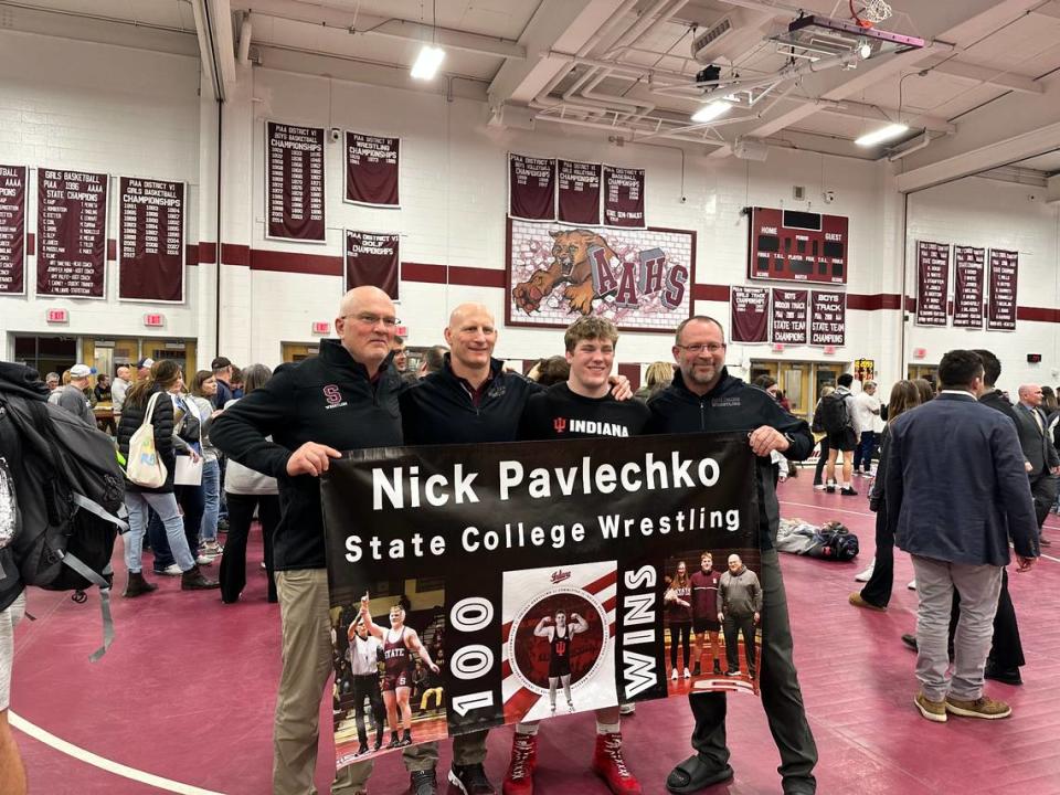 State College’s Nick Pavlechko (middle right) celebrates his 100th win with coaches (from left) Bud Price, Ryan Cummins and Jason Nickal. The senior pinned Hollidaysburg’s Wyatt Maines in the 285-pound finals.