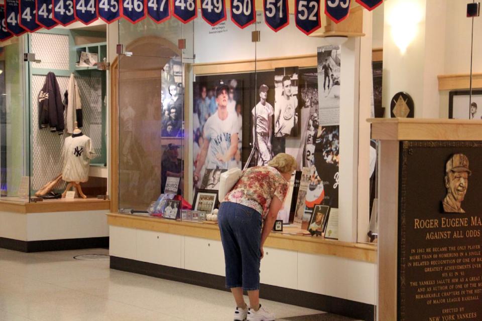 FILE - This July 15, 2013 file photo shows a woman looks at a display on baseball legend Roger Maris Museum in the West Acres Mall in Fargo, N.D. There are many destinations of interest to baseball fans around the country outside ballparks from museums and statues to historic homes. (AP Photo/Mikhail Iliev, File)