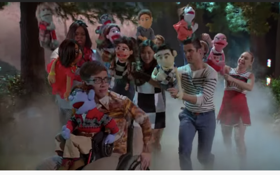 The cast of glee performing "What Does the Fox Say" with puppets