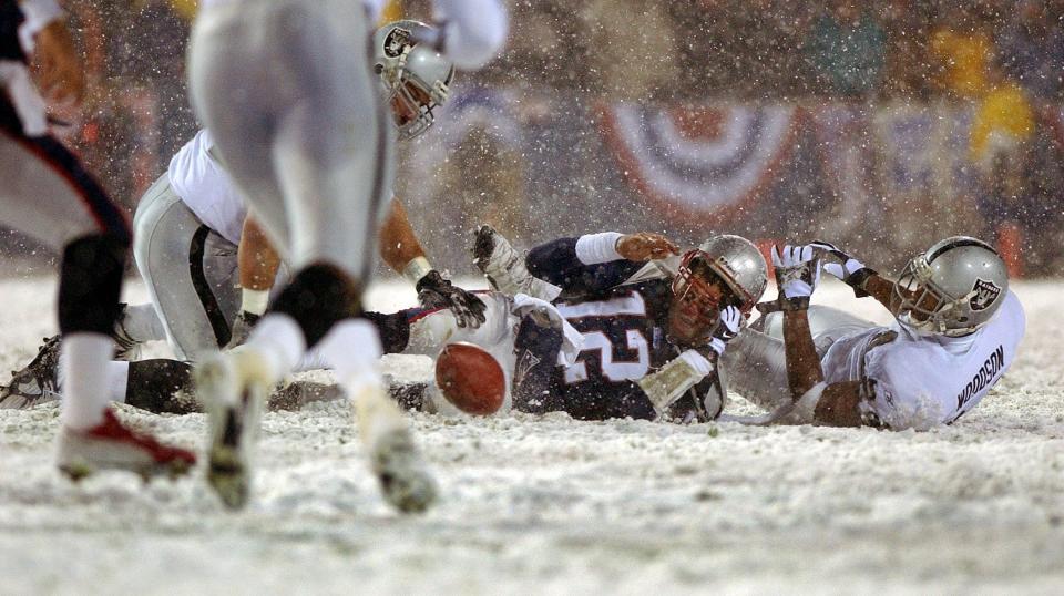 FOXBOROUGH, MA - JANUARY 19: Patriots quarterback Tom Brady loses the ball after being hit by the Oakland Raiders Charles Woodson, right, the fumble was recovered by Greg Biekert, left, but it was ruled an incomplete pass, giving the Patriots another chance. (Photo by Jim Davis/The Boston Globe via Getty Images)