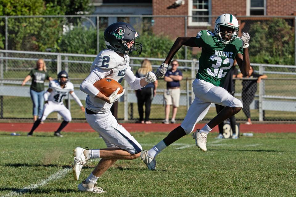 McKean senior Liam Kennedy (2) picks up yards as Mount Pleasant freshman Chukwuma Chukwuocha (32) gives chase on Friday at Mount Pleasant. The Green Knights won 28-26.