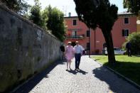 Britain's Prime Minister Theresa May walks with her husband Philip in Desenzano del Garda, by Lake Garda, northern Italy, July 25, 2017. REUTERS/Antonio Calanni/Pool