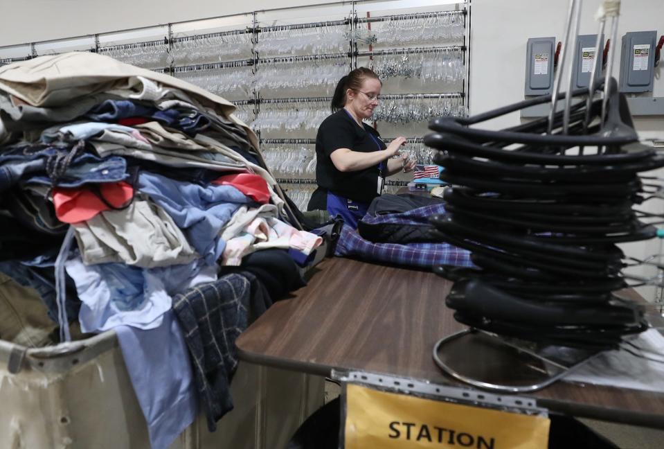Krystal Miller, an attendant donations processor, prepares clothing items to be sold at the Goodwill store on Waterloo Road in Akron on April 26.