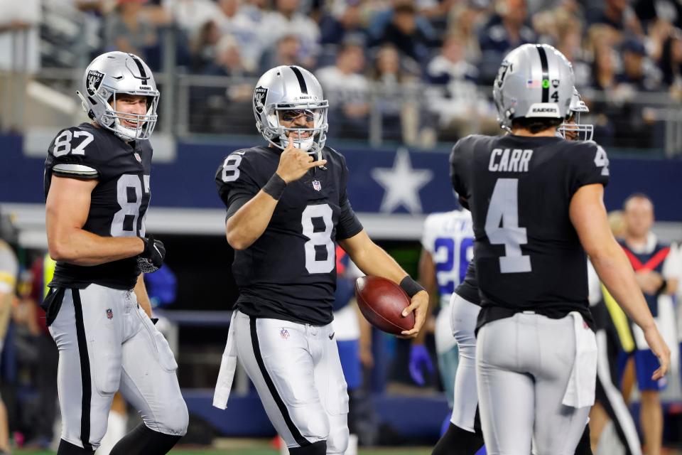 Marcus Mariota (8) celebrates a second-half touchdown run with tight end Foster Moreau (87) and starting quarterback Derek Carr (4) during the Las Vegas Raiders' 36-33 overtime win over the Dallas Cowboys on Nov. 25 in Arlington, Texas.