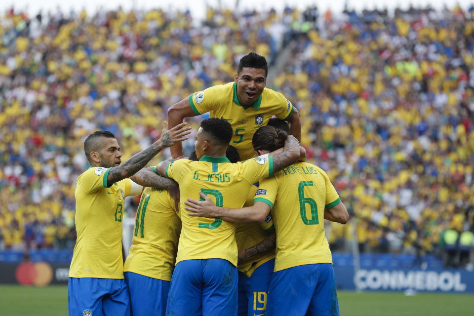 Brazil's Casemiro jumps on teammates surrounding Brazil's Everton after he scoed his side's third goal against Peru during a Copa America Group A soccer match at the Arena Corinthians in Sao Paulo, Brazil, Saturday, June 22, 2019. (AP Photo/Victor R. Caivano)