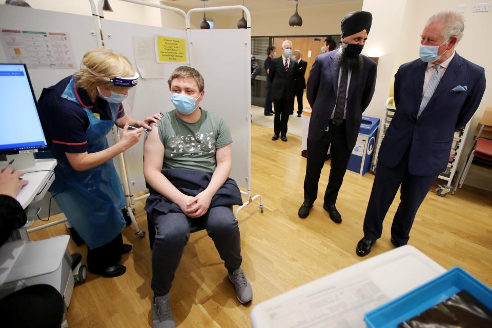 Britain's Prince Charles (R), Prince of Wales and Chief pharmacist Inderjit Singh (C) watch a vaccination taking place during a visit to the Queen Elizabeth Hospital in Birmingham, northern England on February 17, 2021. (Photo by MOLLY DARLINGTON / POOL / AFP) (Photo by MOLLY DARLINGTON/POOL/AFP via Getty Images)