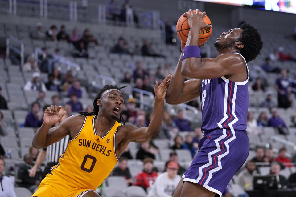 TCU center Ernest Udeh Jr. (8) takes a hit to the arm from Arizona State guard Kamari Lands (0) during the first half of an NCAA college basketball game in Fort Worth, Texas, Saturday, Dec. 16, 2023. (AP Photo/Tony Gutierrez)