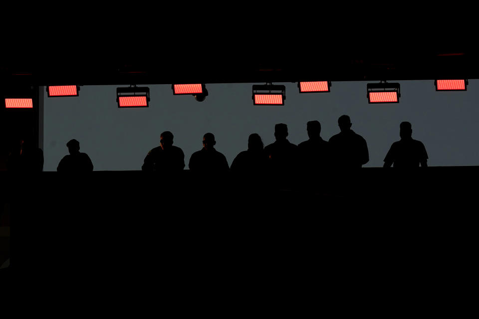 People stand under heat lamps during the first half of an NFL football game between the Kansas City Chiefs and the Green Bay Packers Sunday, Nov. 7, 2021, in Kansas City, Mo. (AP Photo/Charlie Riedel)