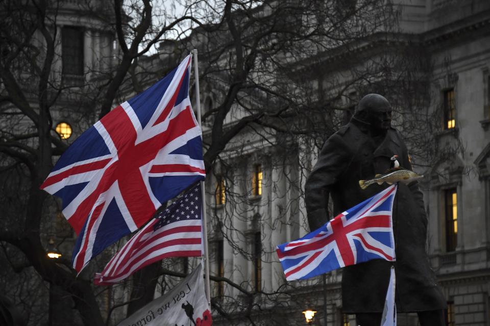 Brexit supporters hold British and US flags in front of the Statue of Winston Churchill during a rally in London