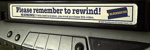 Blockbuster VHS tape with the sticker "Please remember to rewind" sticking out of the VCR