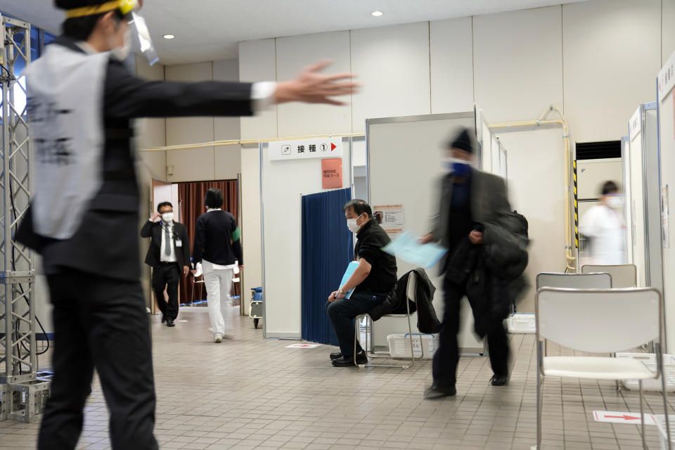 A local resident receives the booster shot of the Moderna coronavirus vaccine at a mass vaccination center operated by Japanese Self-Defense Force Monday, Jan. 31, 2022, in Tokyo. (AP Photo/Eugene Hoshiko, Pool)