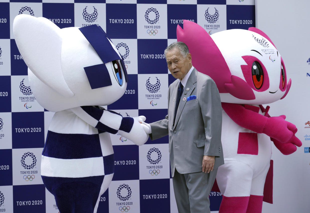 FILE - In this July 22, 2018, file photo, Tokyo 2020 Olympic mascot "Miraitowa," left, and Paralympic mascot "Someity," right, and Tokyo Olympic Organizing Committee President Yoshiro Mori attend at stage during their debut event in Tokyo. Mori resigned Friday, Feb. 12, 2021 as the president of the Tokyo Olympic organizing committee following sexist comments implying women talk too much. (AP Photo/Eugene Hoshiko, File)