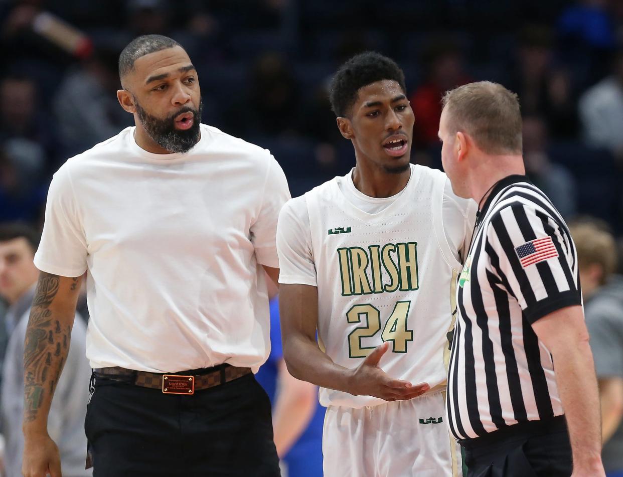 St. Vincent-St. Mary assistant coach Romeo Travis, left, and guard Sencire Harris discuss a play with an official during the 2022 OHSAA Division II state championship in Dayton last week.