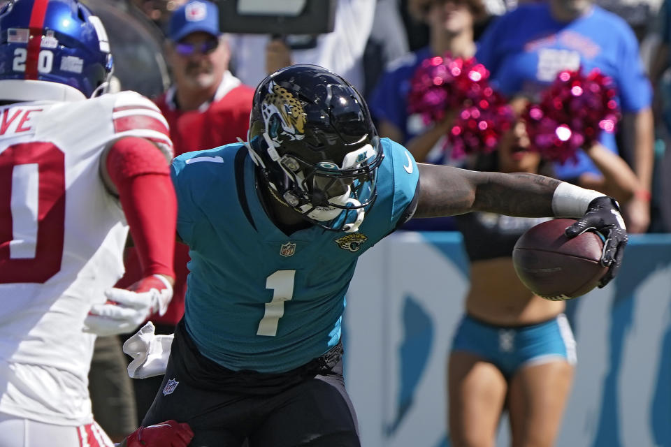 Jacksonville Jaguars running back Travis Etienne Jr. (1) scores past New York Giants safety Julian Love (20) on a 7-yard run during the first half of an NFL football game Sunday, Oct. 23, 2022, in Jacksonville, Fla. (AP Photo/John Raoux)