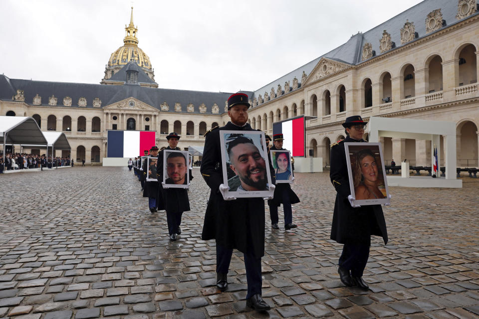 French Republican Guards hold portraits of the French victims of the Oct.7 2023 Hamas' attack, during a ceremony at the Invalides monument, Wednesday, Feb.7, 2024. France is paying tribute to French victims of Hamas' Oct. 7 attack, in a national ceremony led by President Emmanuel Macron four months after the deadly assault in Israel that killed some 1,200 people, mostly civilians, and saw around 250 abducted.(Gonzalo Fuentes/Pool via AP)