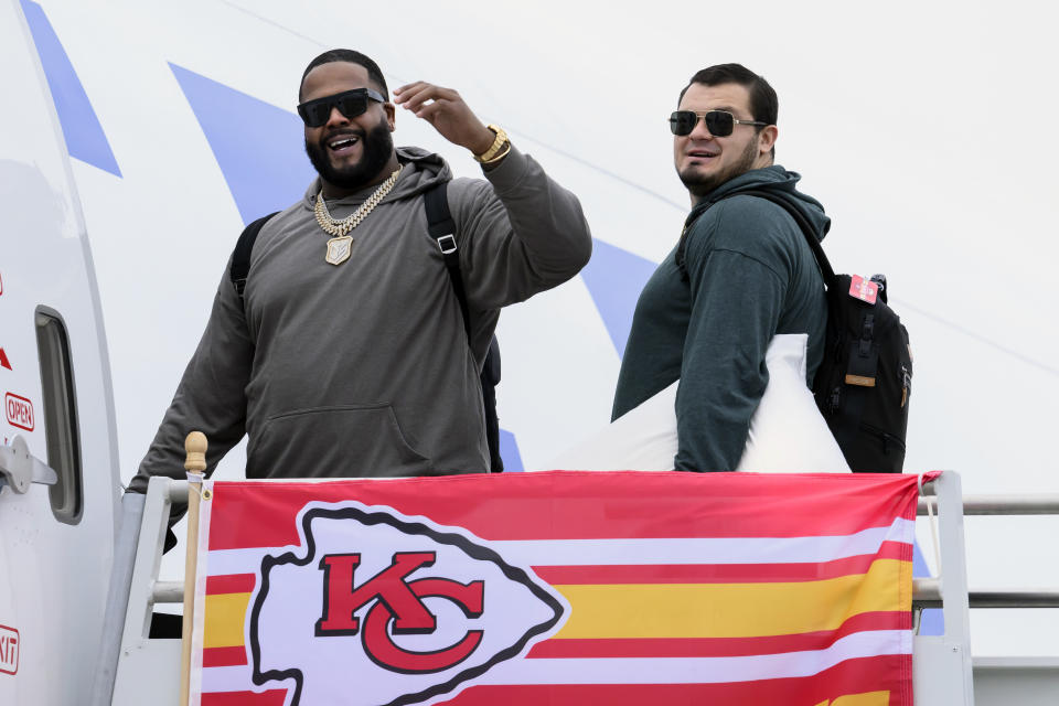 Kansas City Chiefs tackle Donovan Smith, left, and guard Nick Allegretti board a plane with the rest of the team at Kansas City International Airport, Sunday, Feb. 4, 2024, in Kansas City, Mo., bound for Las Vegas and Super Bowl 58. (AP Photo/Reed Hoffmann)