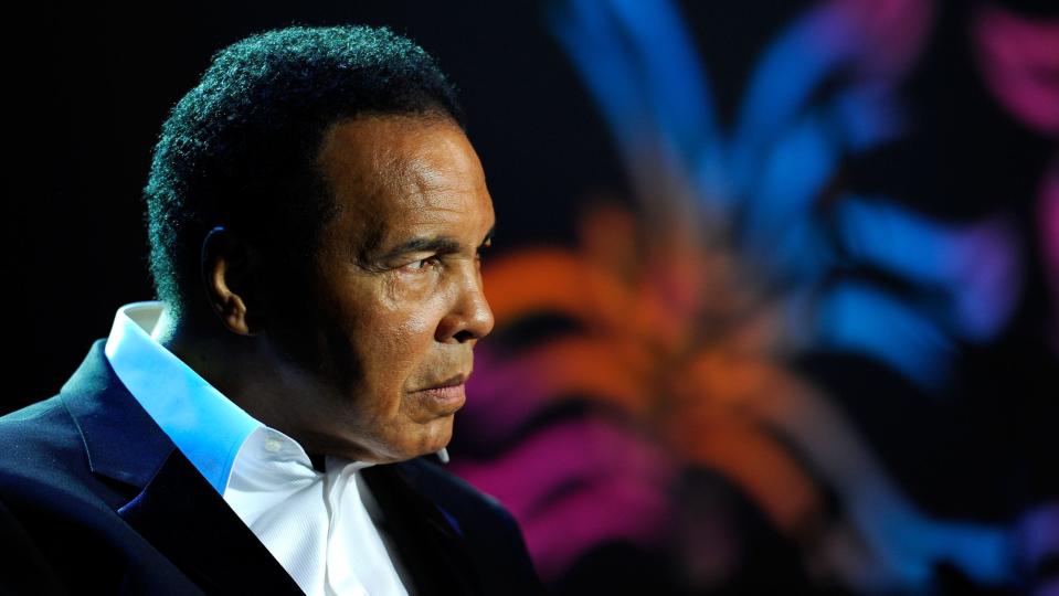Muhammad Ali wearing black suit.