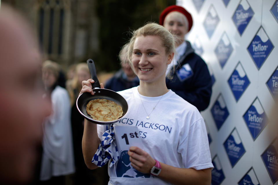 First place finisher Devon Byrne, from Olney, poses for photographers after winning the annual Shrove Tuesday trans-Atlantic pancake race for the third time in a record time of 55.61 seconds, in the town of Olney, in Buckinghamshire, England, Tuesday, March 4, 2014. Every year women clad in aprons and head scarves from Olney and the city of Liberal, in Kansas, USA, run their respective legs of the race with a pancake in their pan, flipping it at the beginning and end of the race. According to legend, the Olney race started in 1445 when a harried housewife arrived at church on Shrove Tuesday still clutching her frying pan with a pancake in it. Liberal challenged Olney to a friendly international competition in 1950 after seeing photos of the race in a magazine. (AP Photo/Matt Dunham)