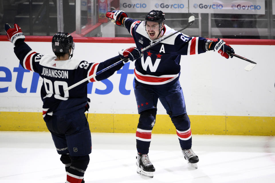 Washington Capitals defenseman Dmitry Orlov (9) celebrates after his goal with left wing Marcus Johansson (90) during overtime of an NHL hockey game against the Detroit Red Wings, Monday, Dec. 19, 2022, in Washington. (AP Photo/Nick Wass)