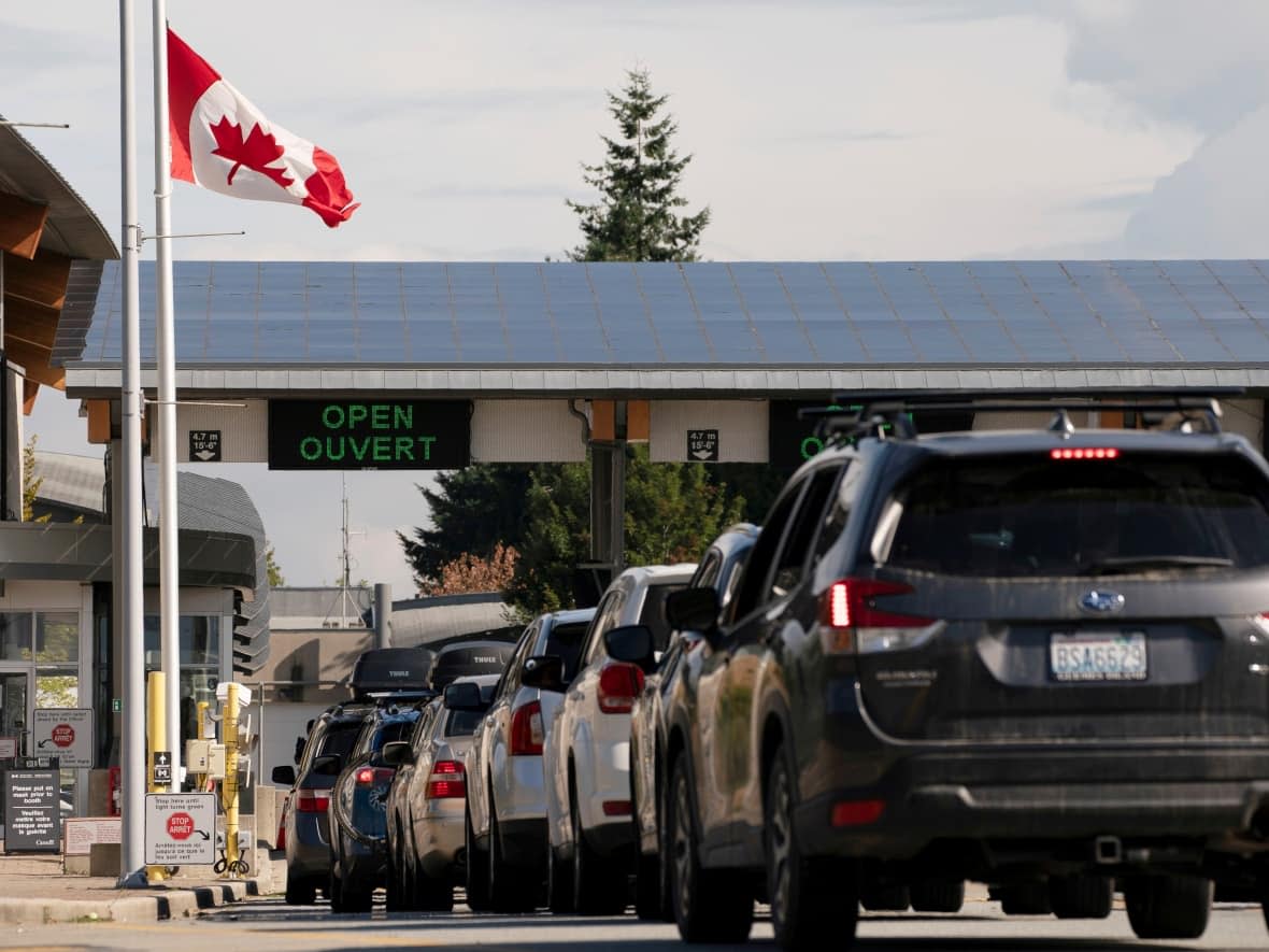 Vehicles line up to cross the U.S.-Canada border in Blaine, Wash., on Aug. 9, after the Canadian government opened the border to vaccinated Americans. (David Ryder/Reuters - image credit)