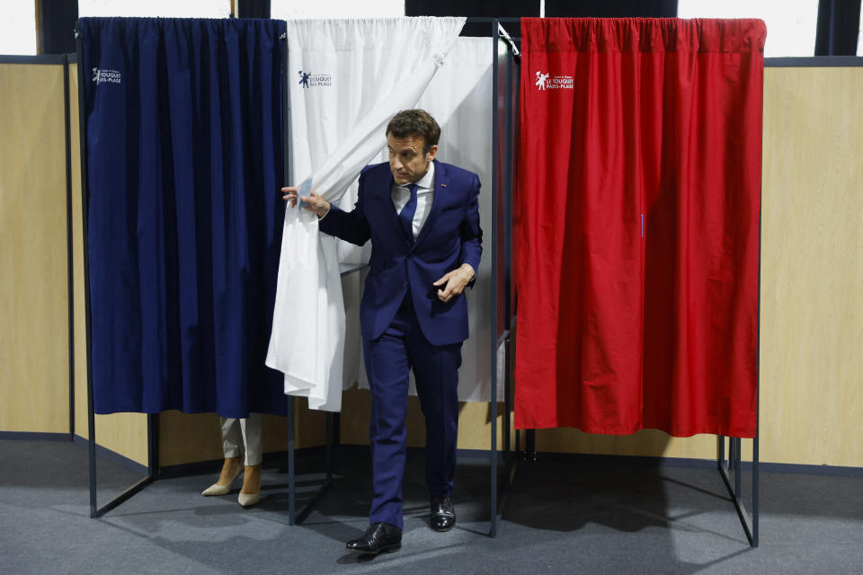French President and centrist candidate for reelection Emmanuel Macron exits the voting booth at a polling station in Le Touquet, northern France, Sunday, April 24, 2022. France began voting in a presidential runoff election Sunday with repercussions for Europe's future, with centrist incumbent Emmanuel Macron the front-runner but fighting a tough challenge from far-right rival Marine Le Pen. (Gonzalo Fuentes; Pool via AP)