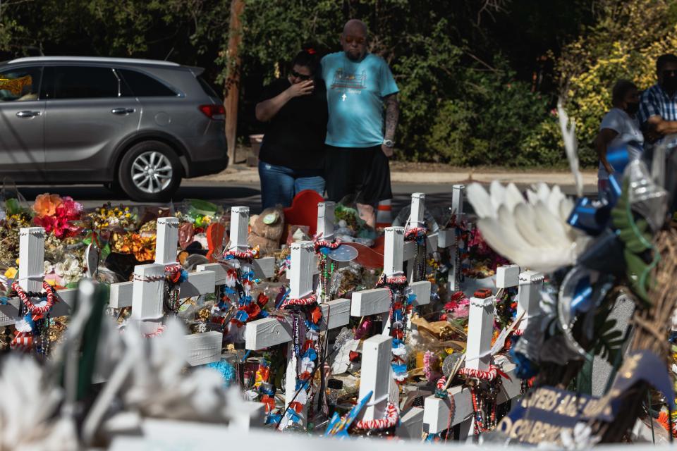 UVALDE, TX - JUNE 24: A couple visits the memorial for the massacre at Robb Elementary School on June 24, 2022 in Uvalde, Texas. Nearly 300 Uvalde High School seniors received their diplomas one month to the day after nineteen children and two adults were killed at Robb Elementary School after a former student entered the school and barricaded himself in a classroom.  (Photo by Jordan Vonderhaar/Getty Images)