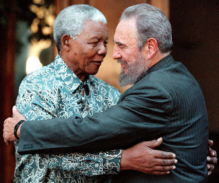 Former South African President Nelson Mandela (L) hugs Cuba's President Fidel Castro during a visit to Mandela's home in Houghton, Johannesburg in this September 2, 2001 file photo. REUTERS/Chris Kotze/File Photo