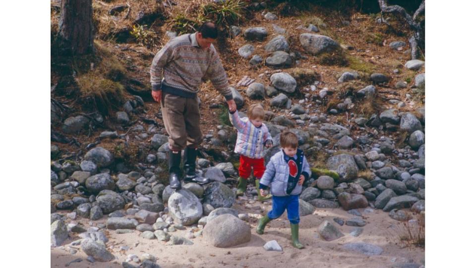 Charles, Prince of Wales, Prince William, and Prince Harry play on the bank of the River Dee, near Balmoral Estate, Scotland, on April 10,1987, in Ballater, Scotland.