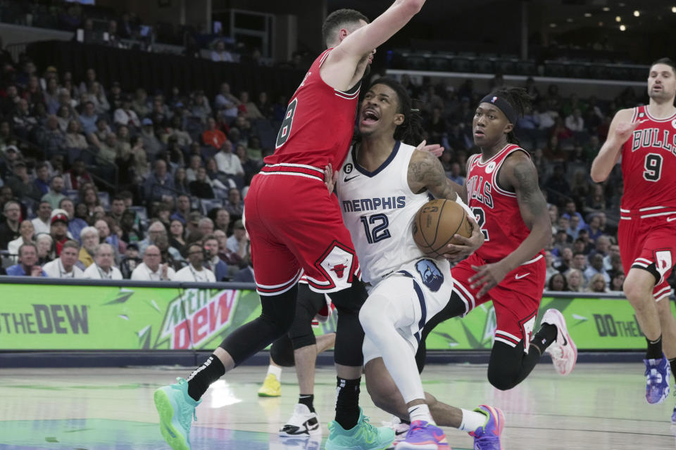 Memphis Grizzlies' Ja Morant (12) is closely defended by Chicago Bulls' Zach LaVine (8) during the first half of an NBA basketball game Tuesday, Feb. 7, 2023, in Memphis, Tenn. (AP Photo/Karen Pulfer Focht)